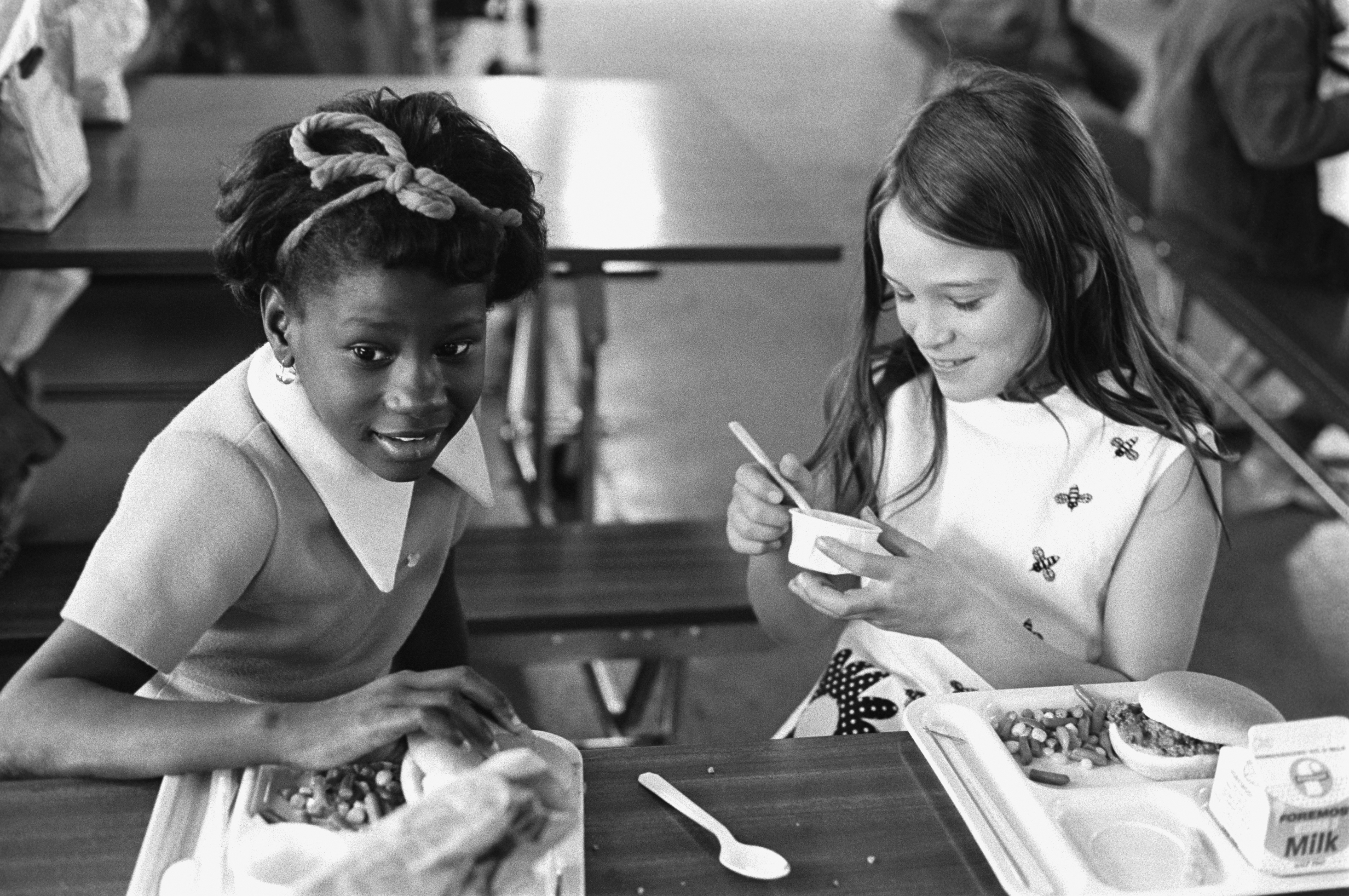 Photo of two young girls eating lunch, in black and white