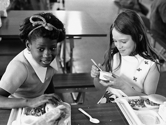 Photo of two young girls eating lunch, in black and white